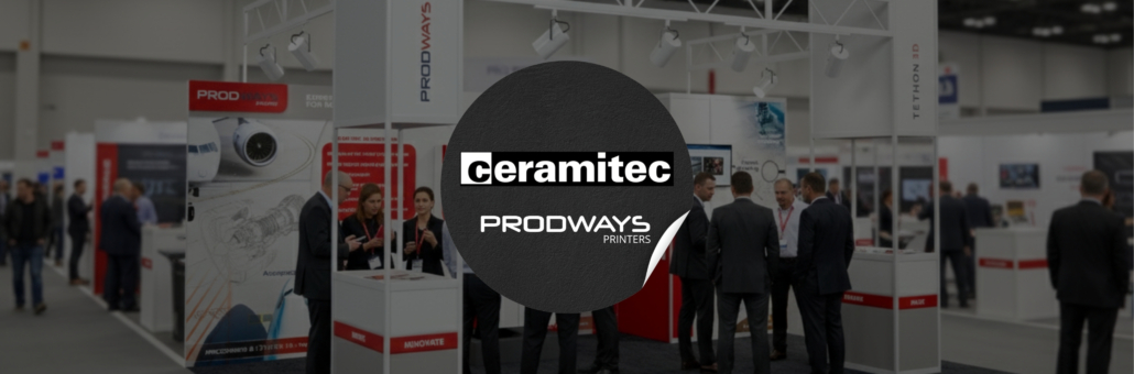 Realistic high-angle photograph of the Prodways and Tethon 3D exhibition stand at the Ceramitec trade show, featuring professional visitors in business attire engaging with staff and 3D printing equipment in a busy convention hall.